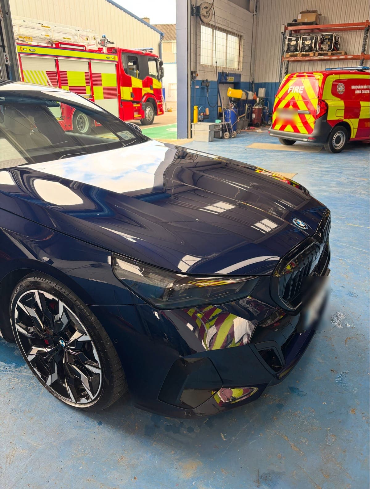 Reflections across the bonnet and alloy wheel of a dark blue BMW 530e